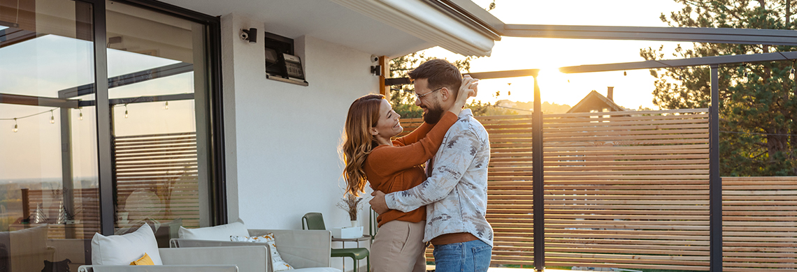 Paar umarmt sich auf Terasse